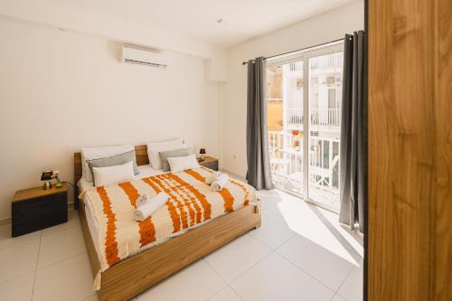 a bedroom with a bed and a large window at Charming Studio & 1BR Apartments Near Sea by Beyond air! Great Location! in Il-Gżira