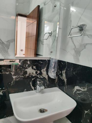 a bathroom with a white sink and a mirror at Prithvi hotel and restaurant in Mussoorie