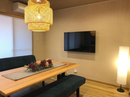 a dining room with a table and a tv at Horomachi iori in Kanazawa
