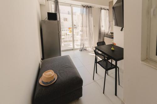 a living room with a couch and a table with a hat at Charming Studio & 1BR Apartments Near Sea by Beyond air! Great Location! in Il-Gżira