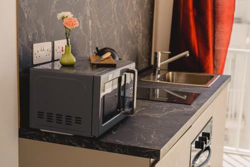 a kitchen counter with a microwave and a sink at Charming Studio & 1BR Apartments Near Sea by Beyond air! Great Location! in Il-Gżira