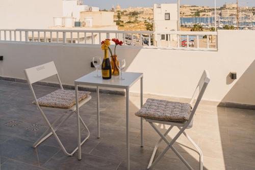 a table with two chairs and a table with wine glasses at Charming Studio & 1BR Apartments Near Sea by Beyond air! Great Location! in Il-Gżira