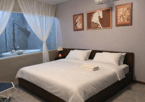 a bedroom with a bed and a tub and a window at Mai Ve Home in Lương Xâm