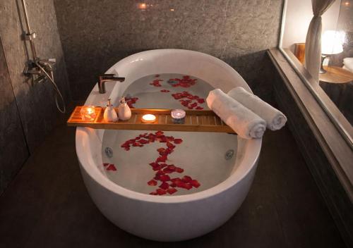 a bathroom with a bath tub with flowers in it at Mai Ve Home in Lương Xâm