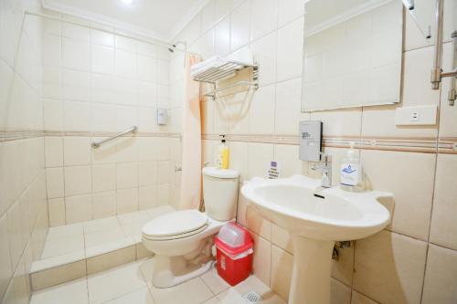 a white bathroom with a toilet and a sink at El Centro Beach Resort Boracay in Boracay