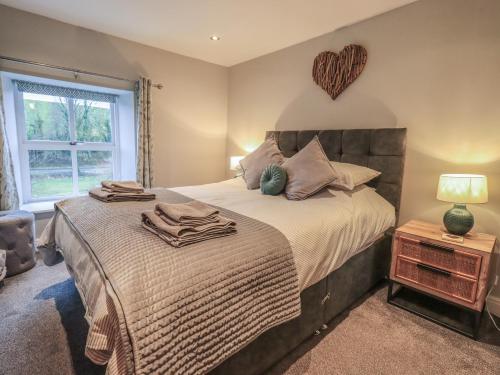 a bedroom with a bed with a heart on the wall at West View in Milnthorpe