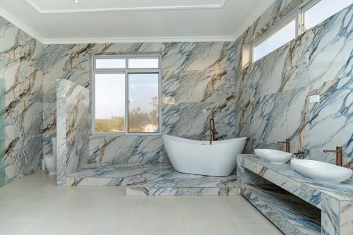 a bathroom with two sinks and a bath tub at Bahari Beach Front Villa in Mdudu Mkubwa
