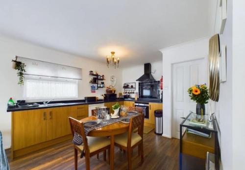 a kitchen with a wooden table and a dining room at Sea Breeze Holiday Chalet in Bridlington