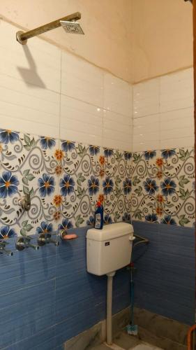 a bathroom with a toilet and a blue wall at Arav Homestay in Rishīkesh