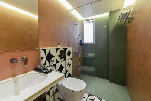 a bathroom with a toilet and a glass shower at Bhagwati luxuria in Indore