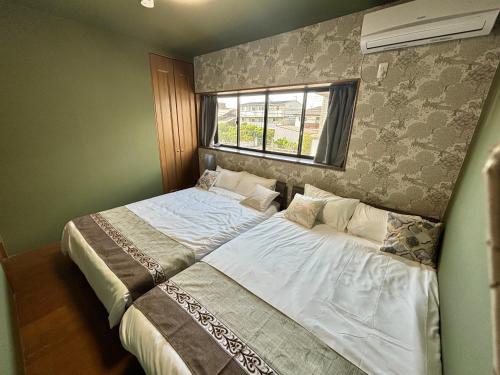 two beds sitting next to each other in a bedroom at HOTTOSTAY OoGANE in Nagoya