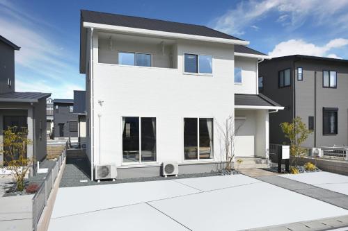 a white house with black at 大津町城下町晶宿 in Ozu