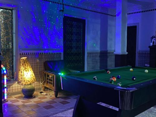 a room with a pool table and a lamp at Beau Riad de 3 chambres avec piscine à la rte d'Ourika in El Jemʼa Ghemat