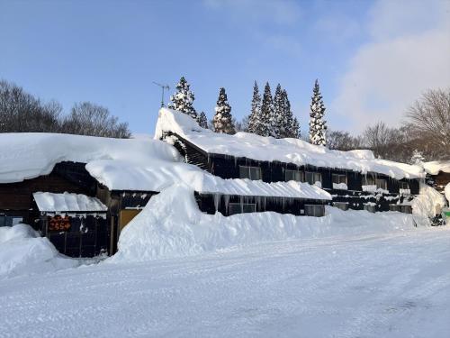 a row of houses covered in snow at Yachi Onsen in Towada