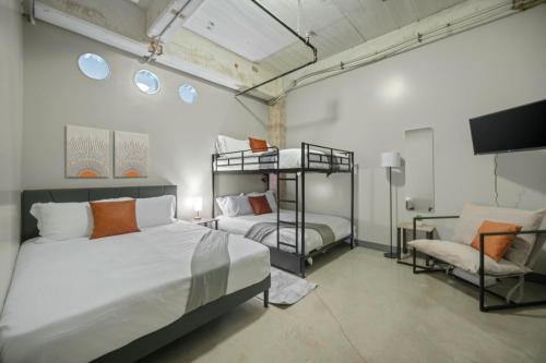 a bedroom with two bunk beds and a chair at Beautiful Downtown Apartment with Pool, Laundry, Parking in Dallas