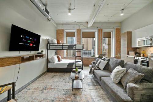 a living room with a couch and a tv at Beautiful Downtown Apartment with Pool, Laundry, Parking in Dallas