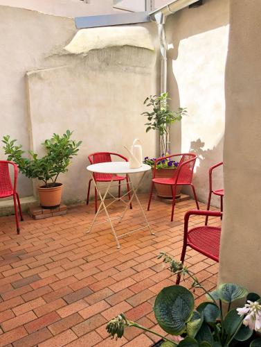a patio with red chairs and a white table at Das Brunnenhaus in Tangermünde