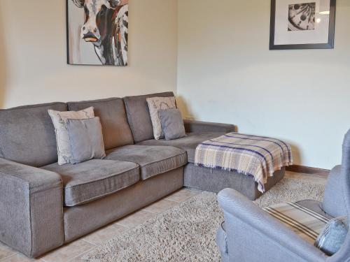 a living room with a brown couch and a chair at The Buttery in Marros