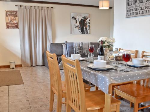 a dining room with a table with chairs and wine glasses at The Buttery in Marros