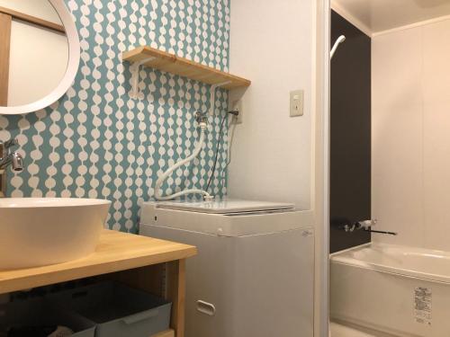 a bathroom with a sink and a toilet and a mirror at Horomachi iori in Kanazawa