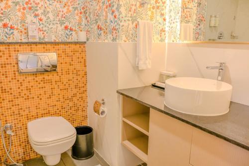 a bathroom with a white toilet and a sink at Terrea by Wonderla in Kumbalgod