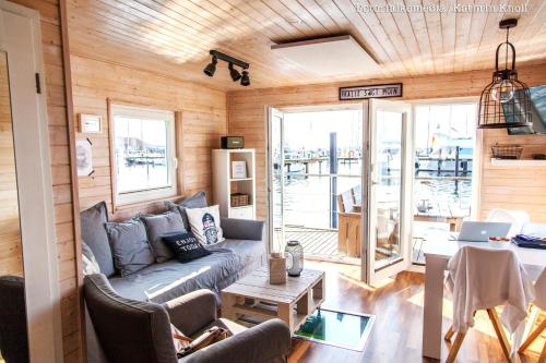 a living room with a couch and a table at Hausboot Koje Kalle Heiligenhafen in Heiligenhafen
