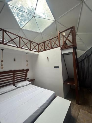 a bedroom with a bed and a skylight at Sinharaja Geo Dome in Nelluwa