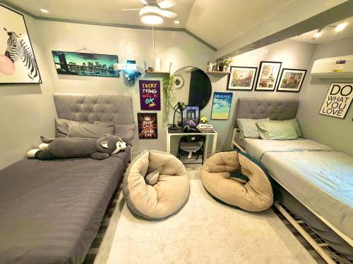 a bedroom with two beds and two ottomans at Gray Room The White Haven In Clark in Angeles