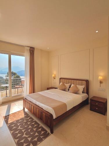 a bedroom with a large bed and a large window at Barylia in Mawlyngkhung