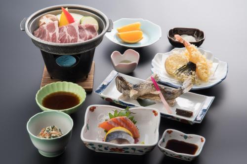 a table topped with plates and bowls of food at Yachi Onsen in Towada