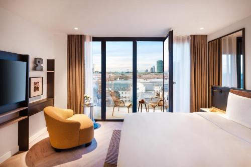 a hotel room with a large bed and a television at Kennedy 89 Hotel Frankfurt, part of Hyatt in Frankfurt