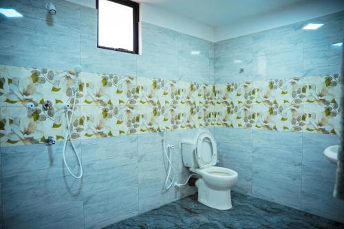 a bathroom with a toilet and a shower at Guru Guest House in Trincomalee