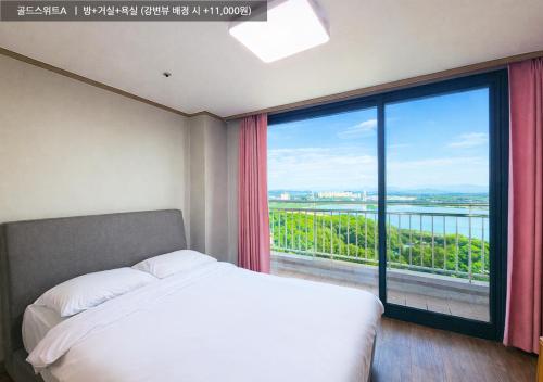 a bedroom with a bed and a large window at Ilsung Condo Namhan River in Yeoju
