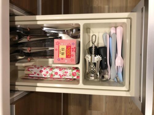 a cupboard filled with utensils and a drawer at Horomachi iori in Kanazawa