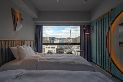 a bedroom with two beds and a large window at Mercure Kyoto Station in Kyoto