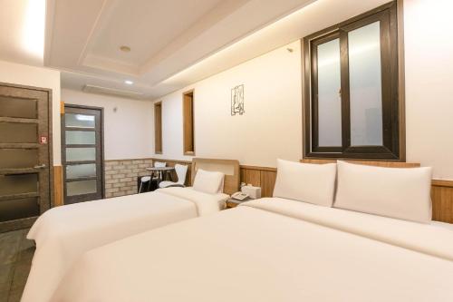 a room with two beds and a window at Yeongdeungpo Komodo Hotel in Seoul