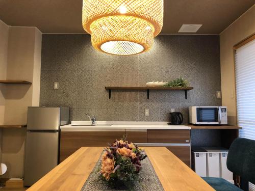 a kitchen with a table and aendant light at Horomachi iori in Kanazawa