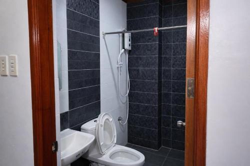 a bathroom with a toilet and a sink and a shower at La Elliana Hotel & Restaurant, Inc. in Laoag