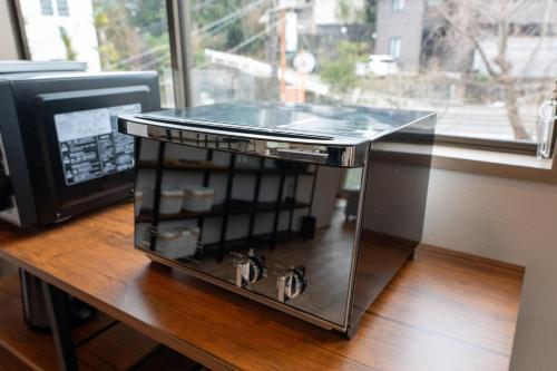 a small glass table on a wooden table at Umi no SOBA 伊豆 - BBQ & Sauna in Ito