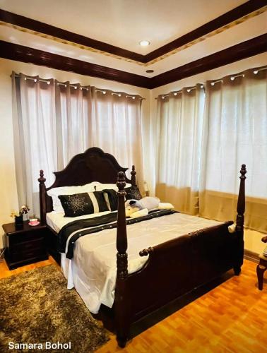 a bedroom with a large bed in front of windows at Samaravilla in Tagbilaran City