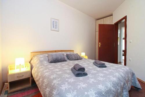 a bedroom with a bed with two towels on it at APARTMANI DELAS in Pješčana Uvala
