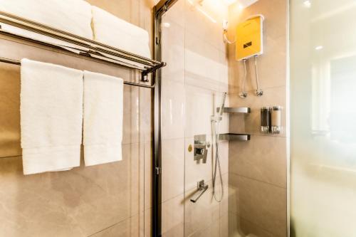 a bathroom with a shower with white towels at Beijing Daxing Apartment in Ban Doung
