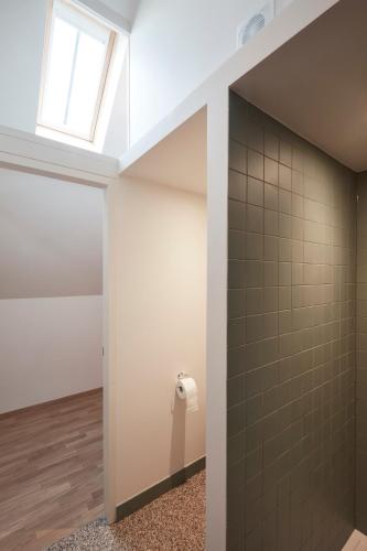 Sint-DenijsにあるB&B De Deugdzondeの窓付きのバスルーム、壁にトイレが備わります。