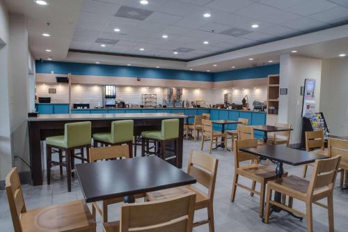 a restaurant with tables and chairs and a counter at Country Inn & Suites by Radisson, Harlingen, TX in Harlingen