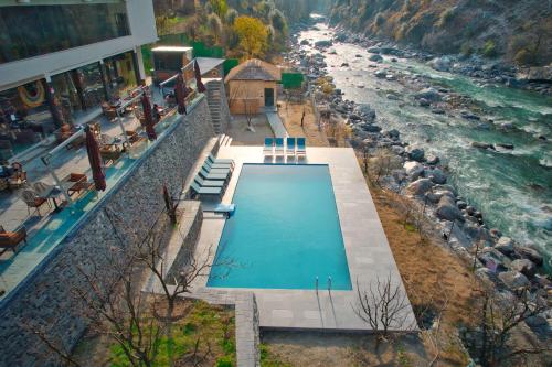 an overhead view of a swimming pool next to a river at Echor Palm Bliss Resort & Spa, Kasol in Kasol