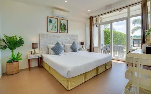 a bedroom with a large bed and a large window at The Mansion Boutique Hotel in Mabalacat
