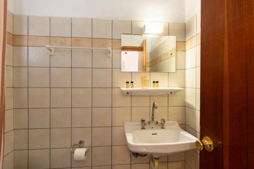 a bathroom with a sink and a mirror at Sailor's Apartments Kavos in Kavos
