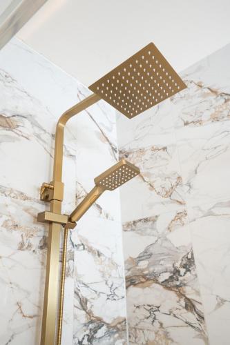 a lamp in a bathroom with a marble wall at Rayya Suites, Paihia in Paihia