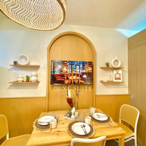 a dining room with a wooden table and chairs at Cozy Vibes near MOA & NAIA AIRPORT with NETFLIX,MINIVIDEOKE,BOARDGAMES-DUXE3 in Manila