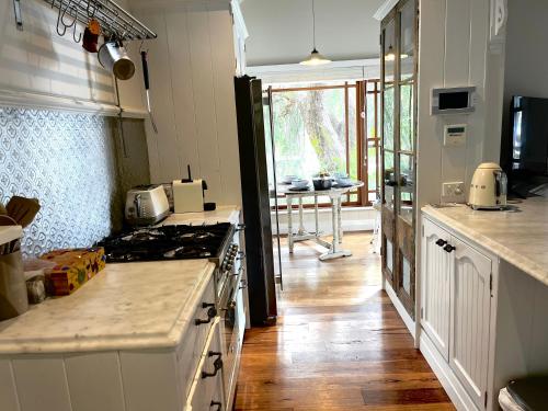 a kitchen with white counters and a stove top oven at The Haven Cottage Point Sydney